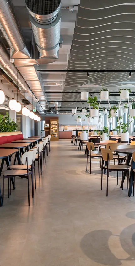 Weitwinkel Cafeteria mit roter Sitzbank.