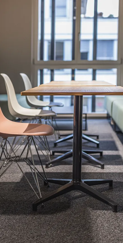 Sitzbank gepolstert mit Tisch und Stühlen in grün und rosa Pastelltönen