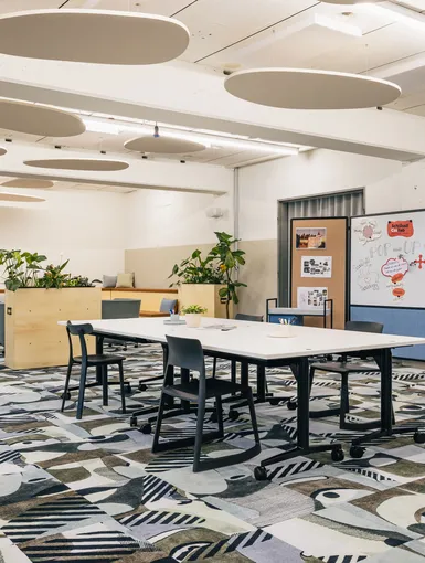 Meetingraum mit weißem Tisch und grauen Stühlen