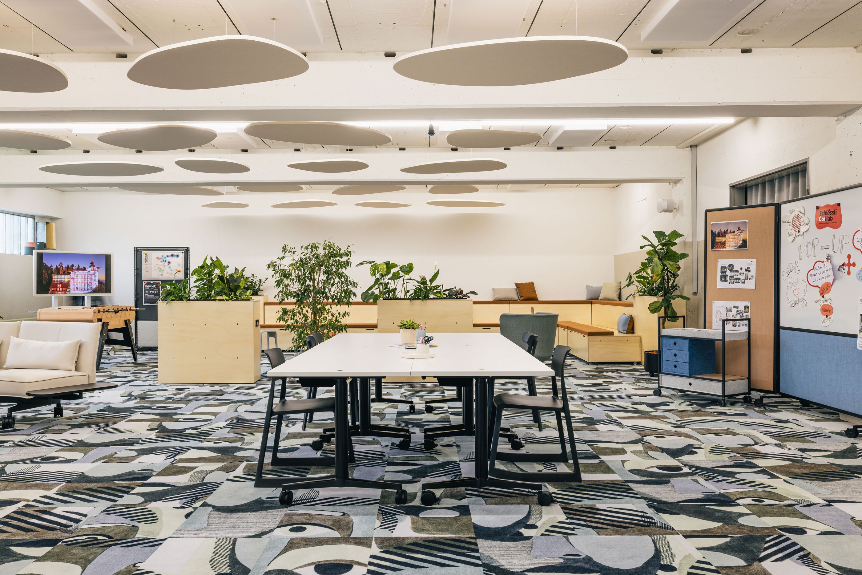 Modernes Open-Space Büro mit hellen Möbeln und kreativem Teppichdesign