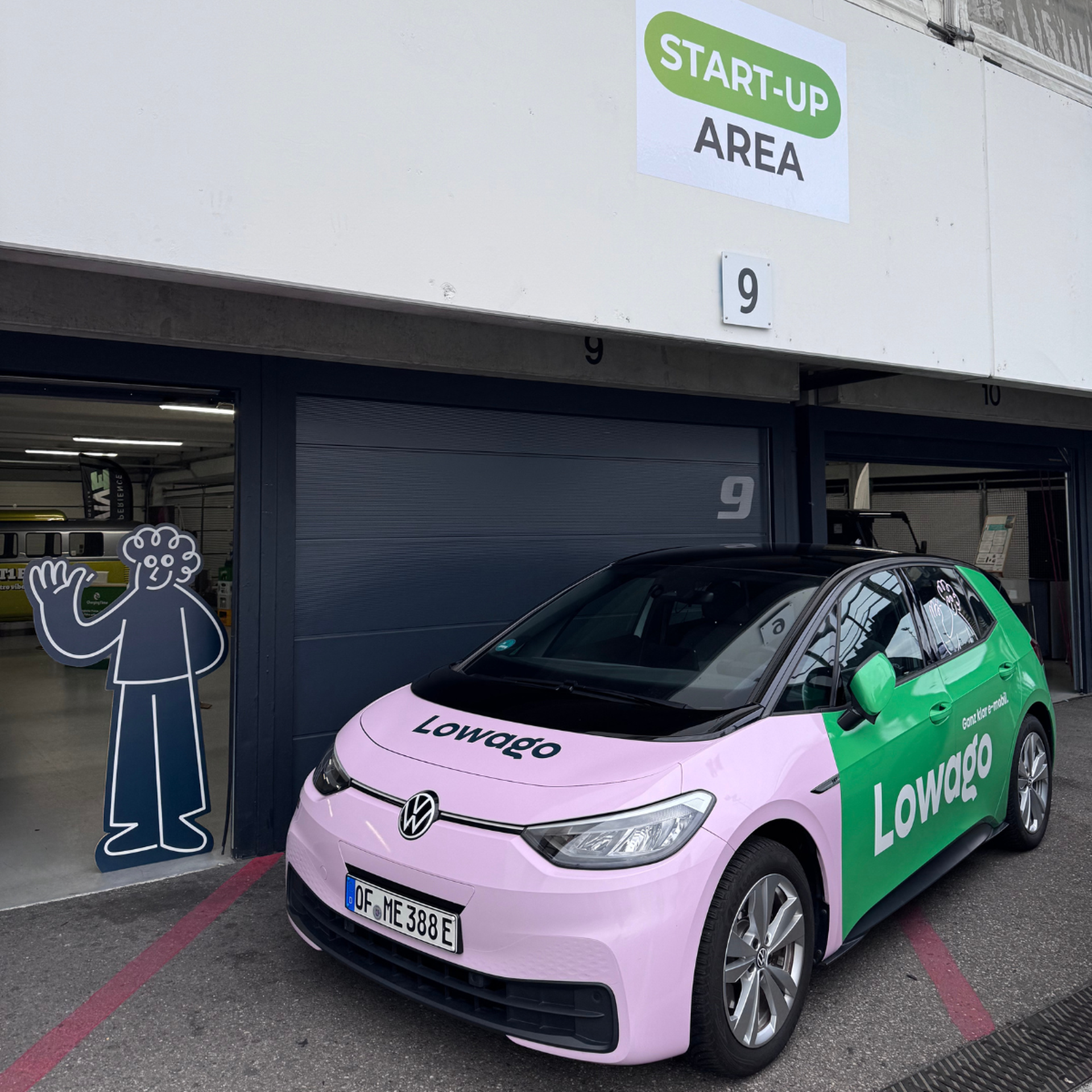 Start-Up Area auf dem e4-Testival. Lowago Auto ist vor dem Boxenlager geparkt.