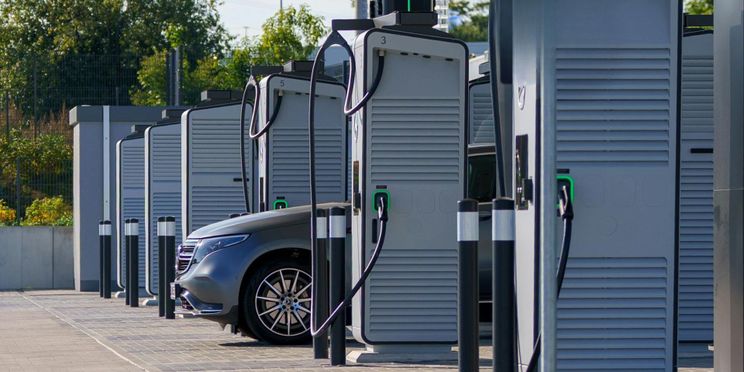 Elektroauto lädt in einem modernen Ladepark mit vielen Schnellladesäulen
