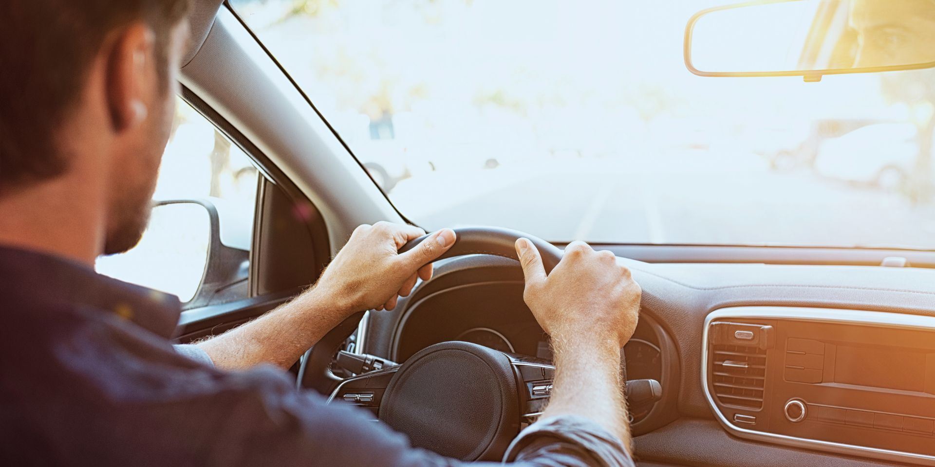 Mann sitzt am Steuer eines modernen e-Autos und fährt