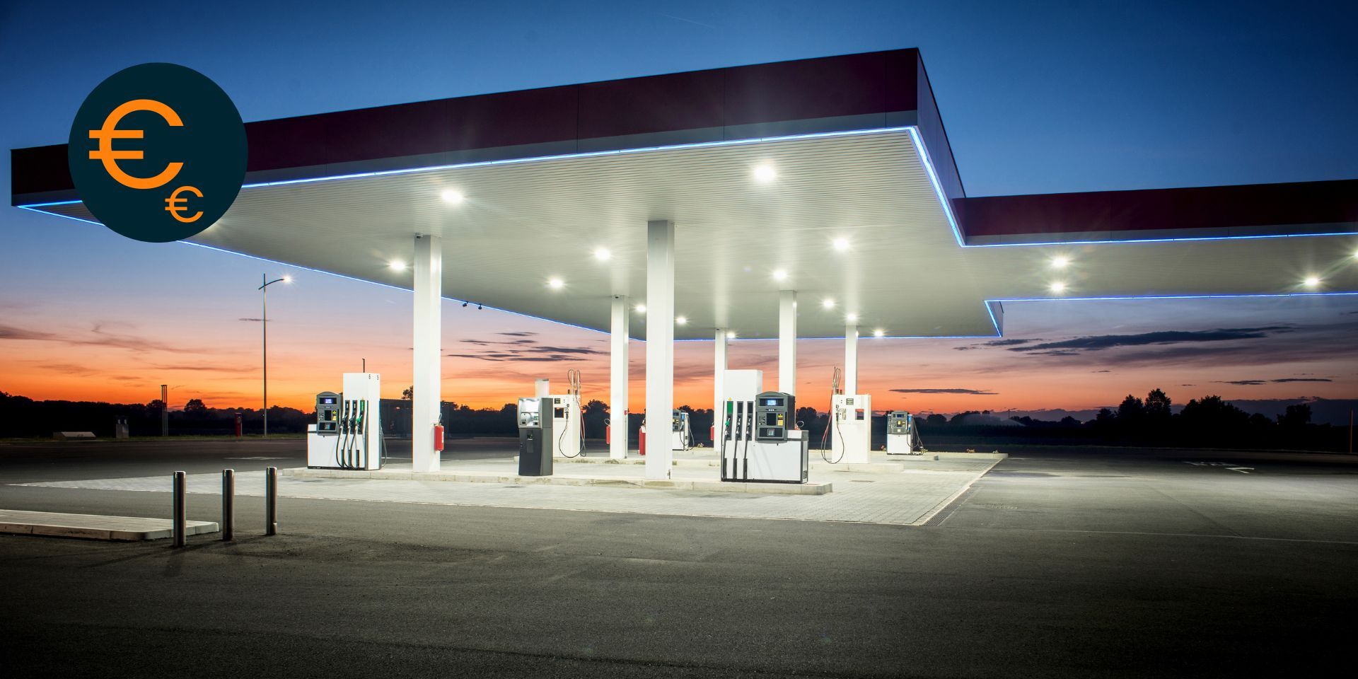 Eine beleuchtete moderne Tankstelle mit Zapfsaeulen und Ladesaeulen bei Sonnenuntergang