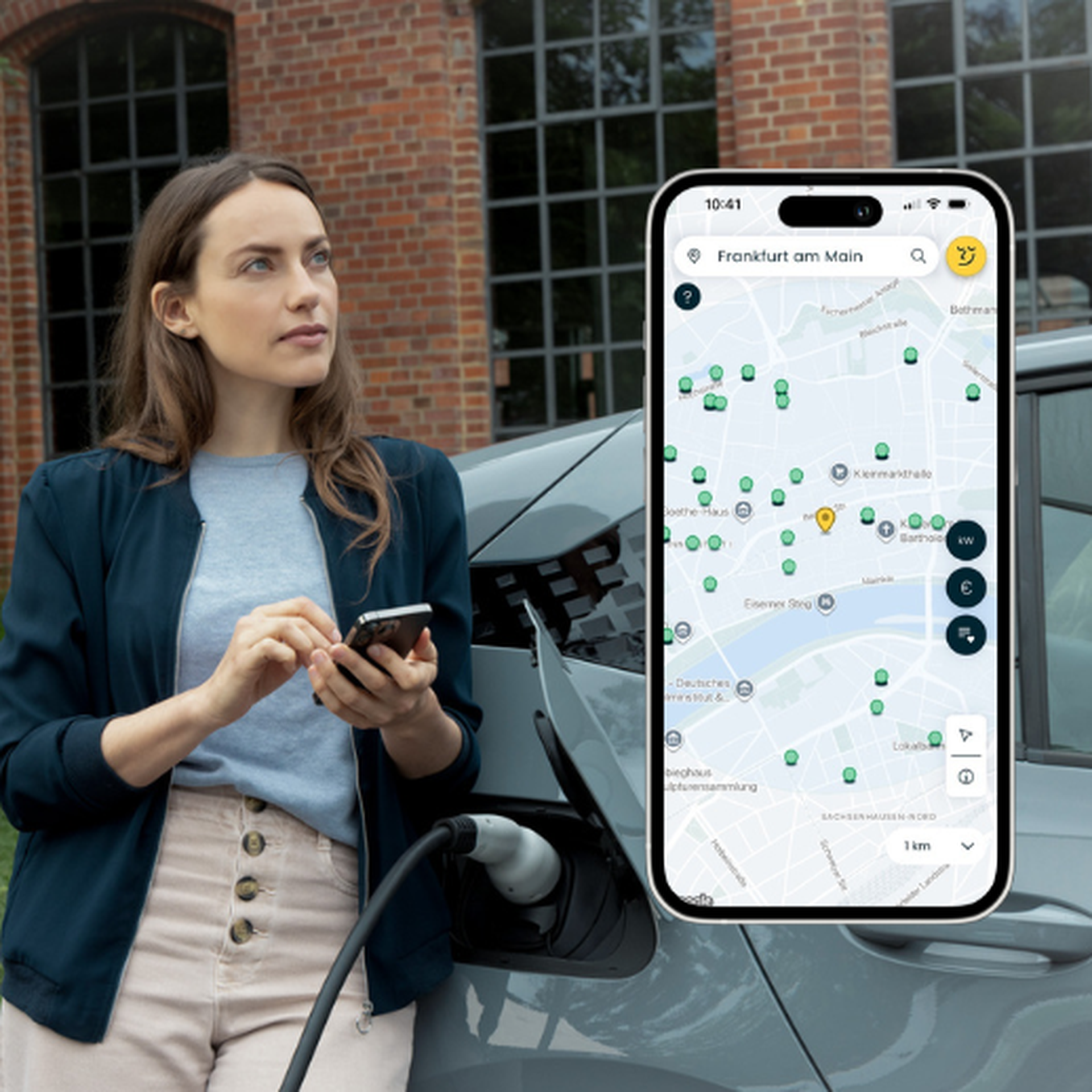 Eine Frau steht neben einem e-Auto und hält ein Handy in der Hand, auf dem die Lowago App geöffnet ist.
