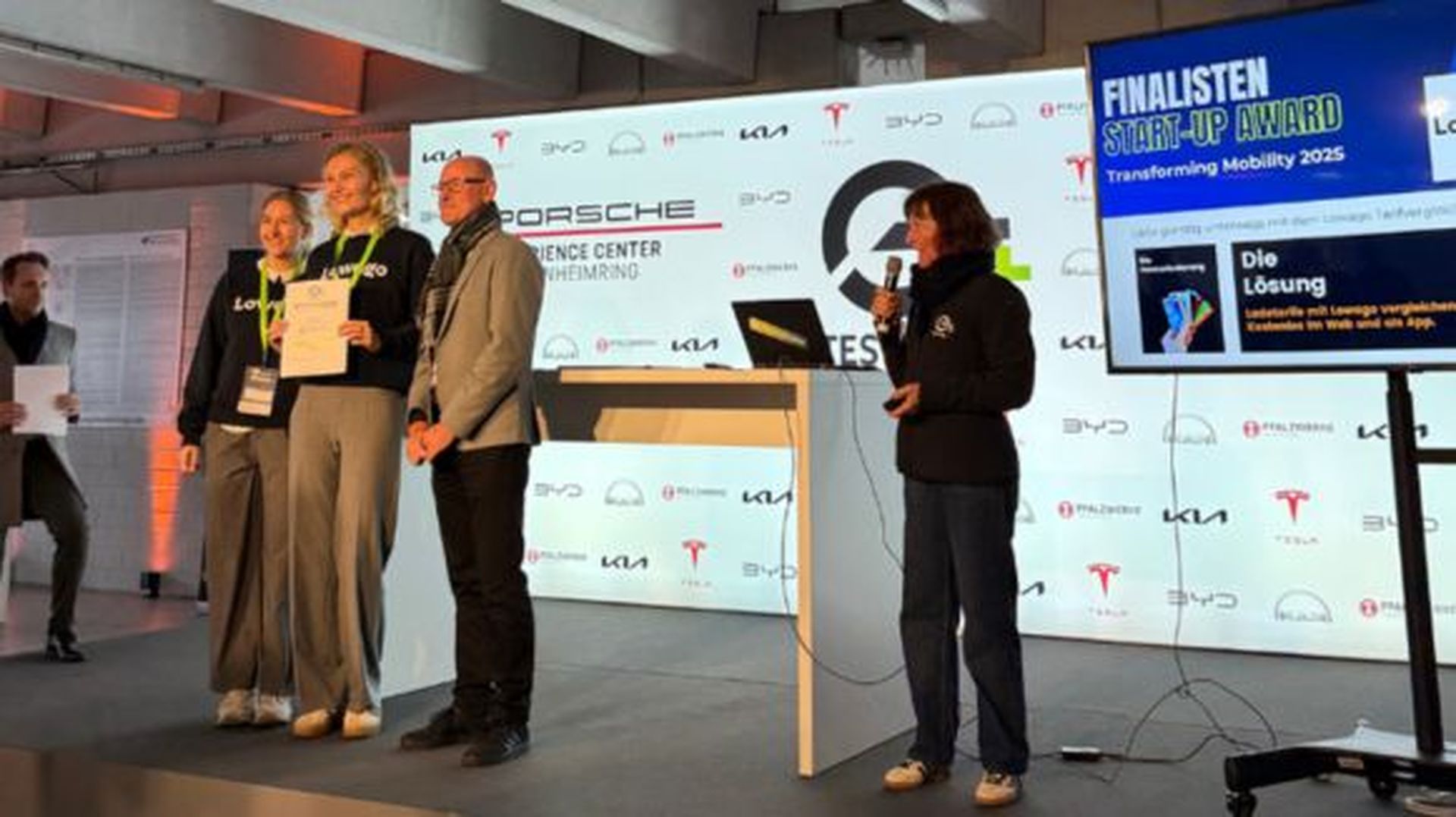 Lowago Team steht auf einer Bühne und hält die Auszeichnung für den Start-Up Award in der Hand.