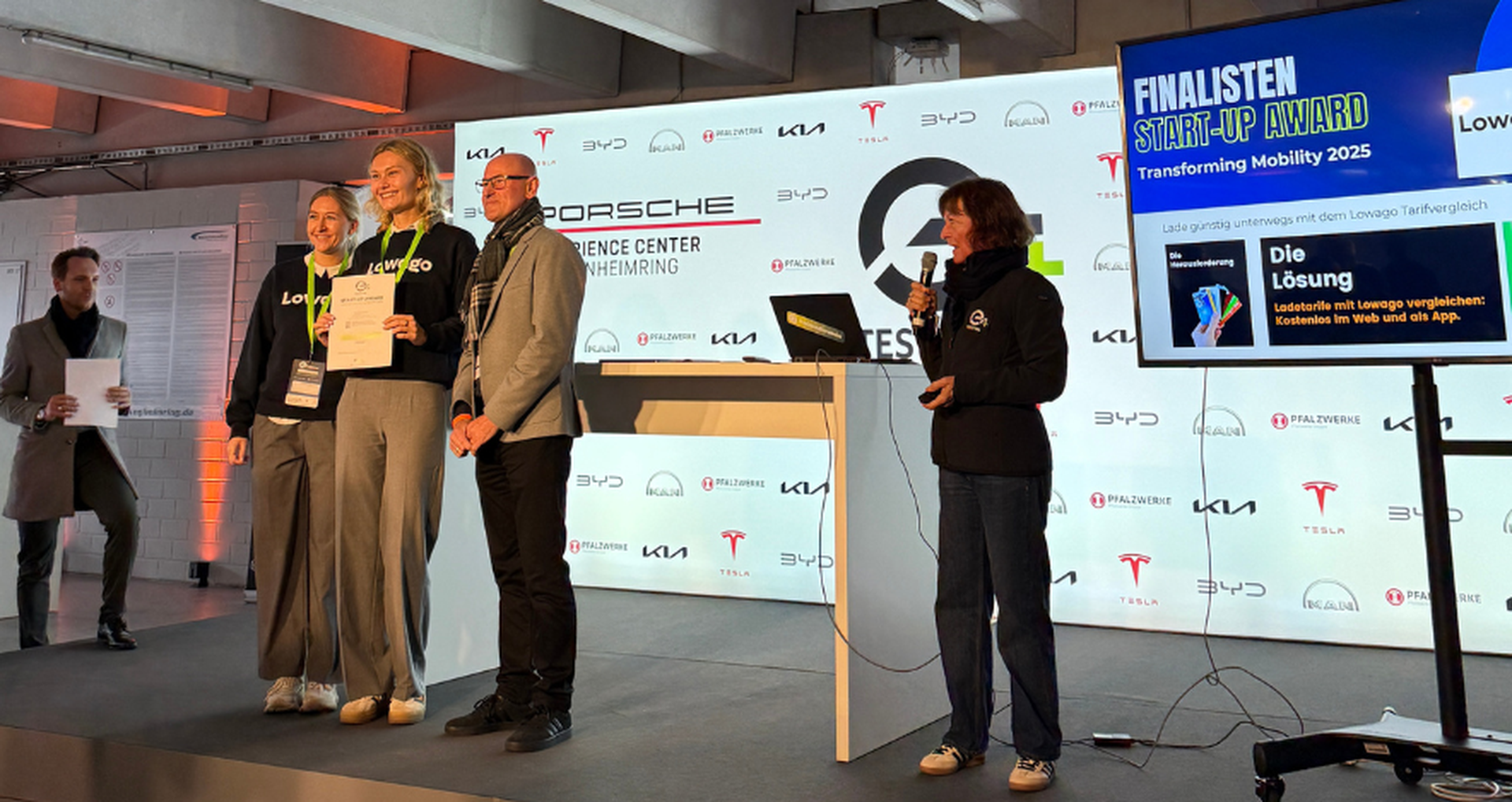 Lowago Team steht auf einer Bühne und hält die Auszeichnung für den Start-Up Award in der Hand.