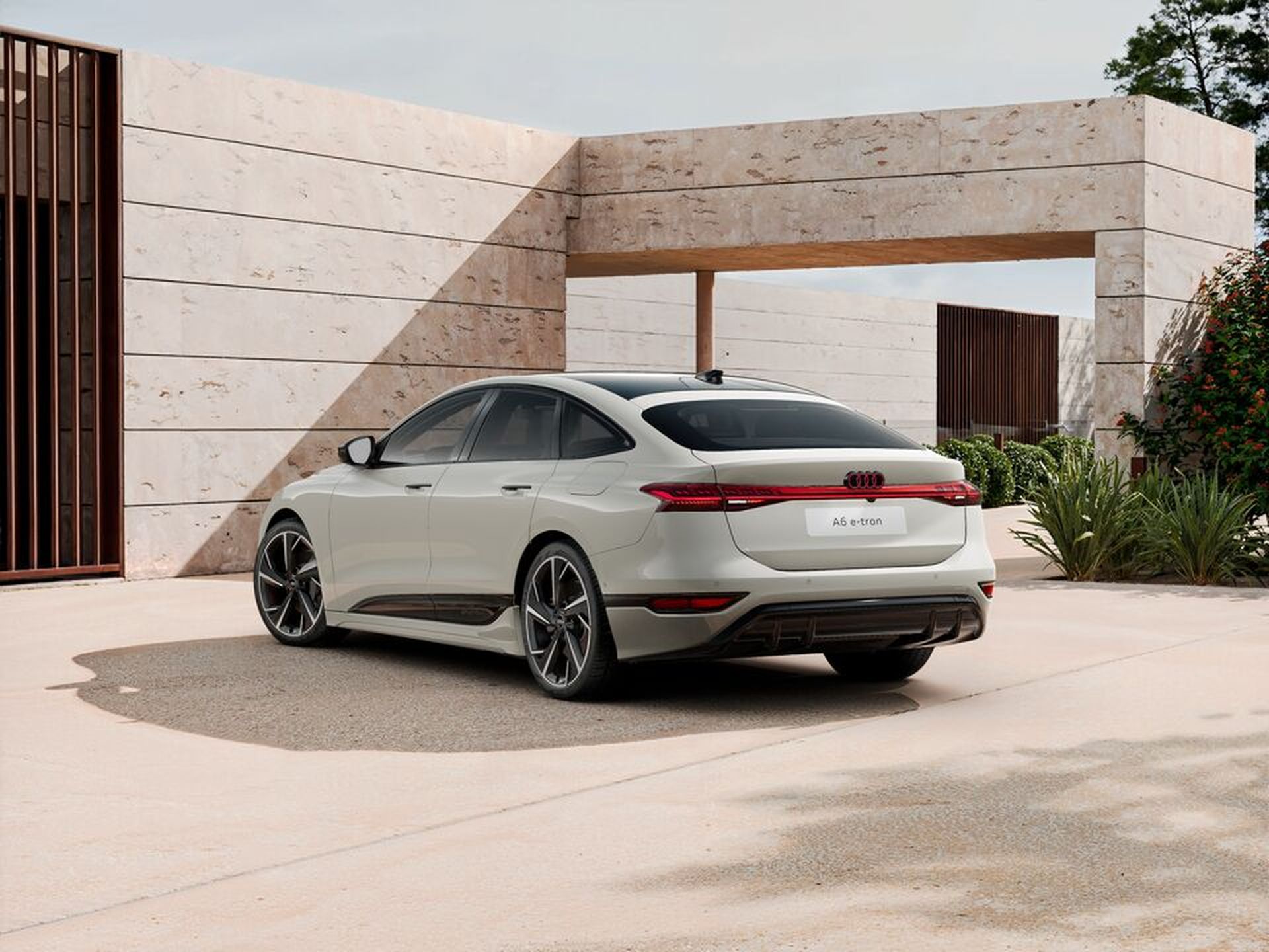 In sommerlicher Umgebung steht ein Audi A6 e-tron in weiß.