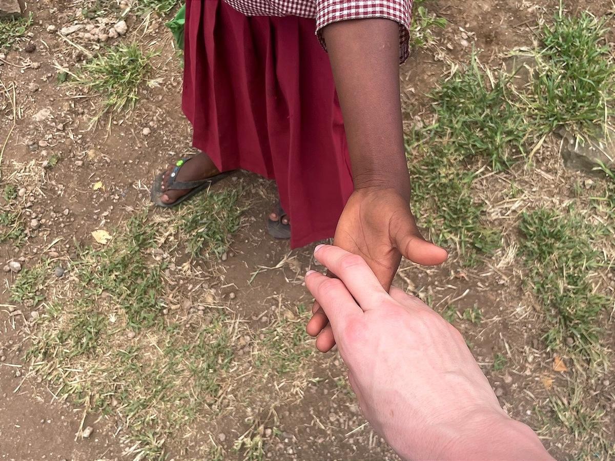 Eine Kinderhand und eine Erwachsenenhand greifen nacheinander.