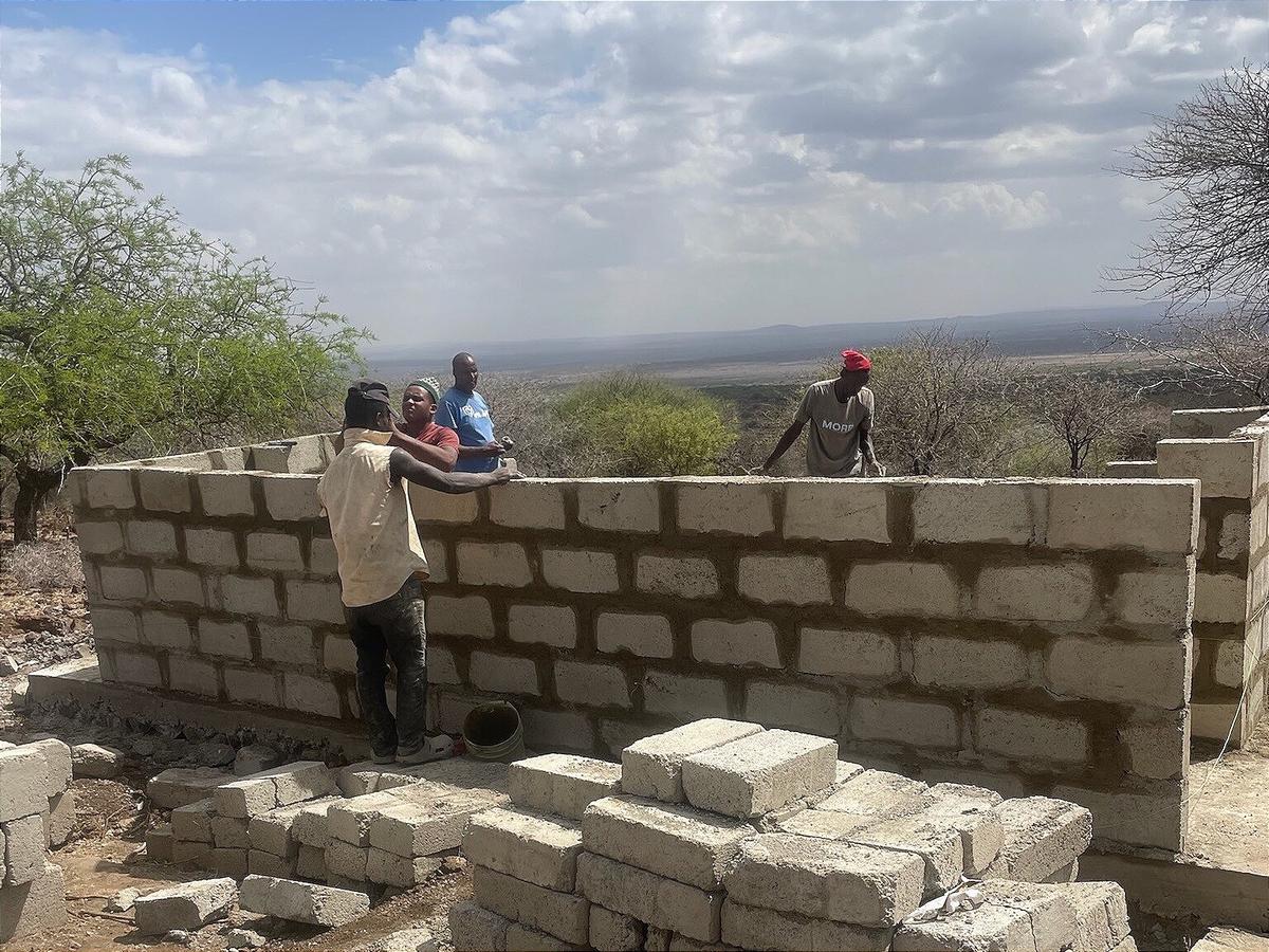 Erste Blockreihen, Menschen arbeiten auf der Mauer.