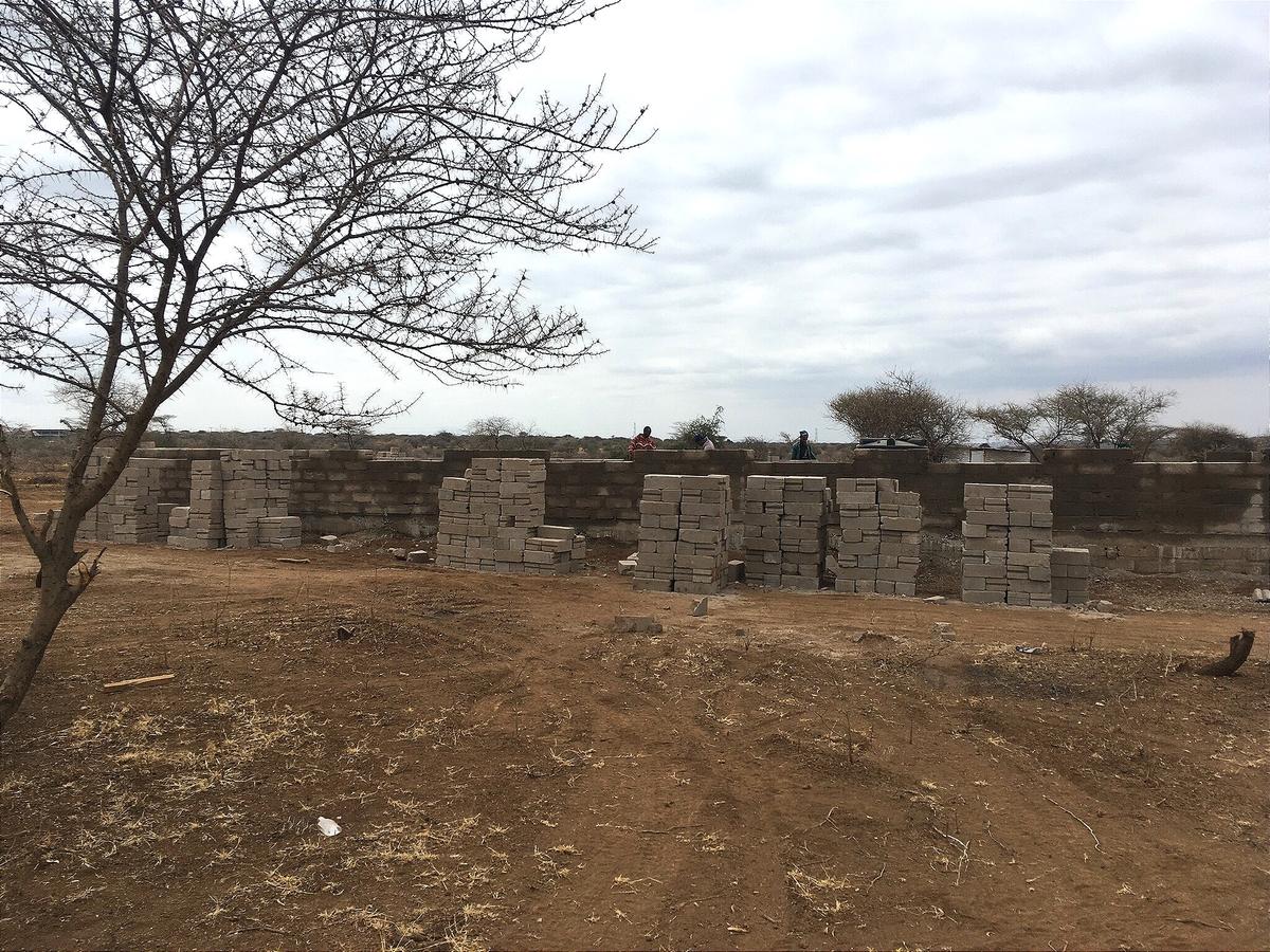 Erste Blockstapel und Fundamentreihen auf dem gerodeten Land.