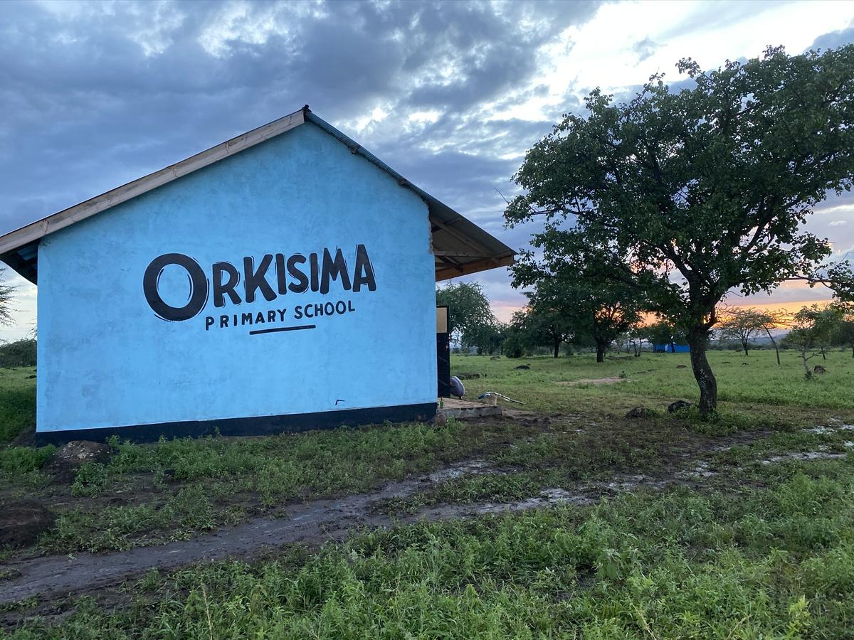 Orkisima Primary School - Schulgebäude mit Schulkindern in blauen Uniformen