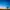 Satellite dish against a clear blue sky with a sunset horizon, surrounded by a flat, grassy landscape.