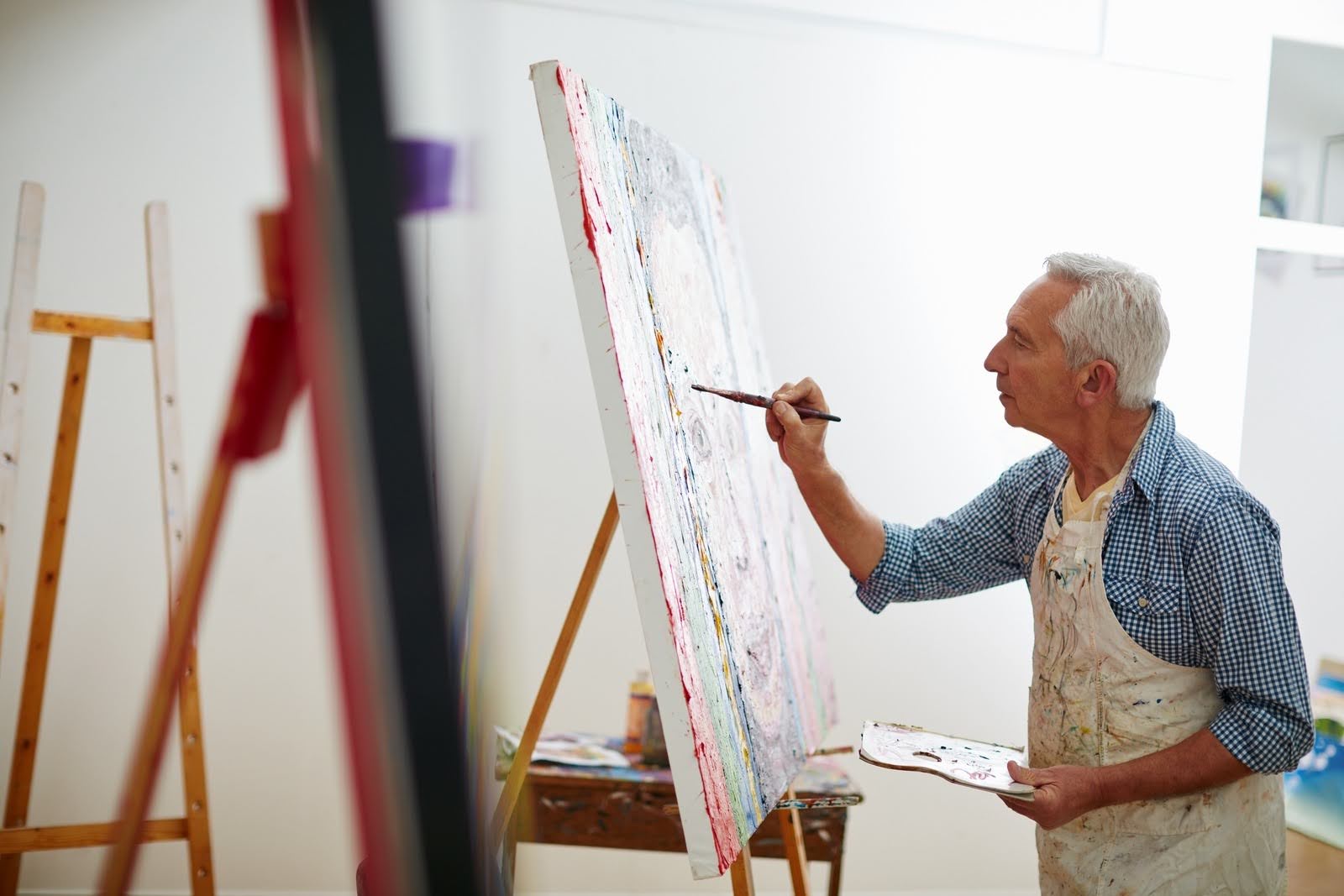 Older man working on a painting