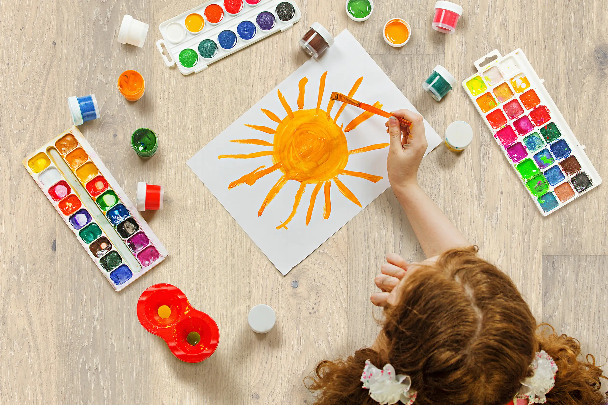 A girl drawing on wood floor