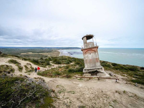 Abandoned lighthouse at Cabo San Pablo overlooks turquoise waters and coastal landscape in Patagonia.
