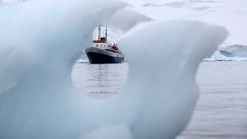 Research vessel navigates through icebergs in Antarctic waters during polar expedition.