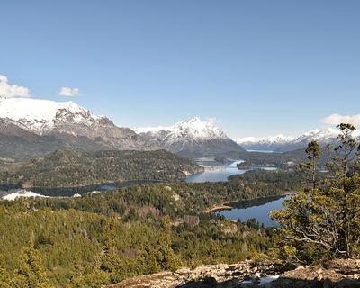 Snow-capped mountains and pristine lakes surrounded by dense forests in the Lake District region of Patagonia, Argentina.