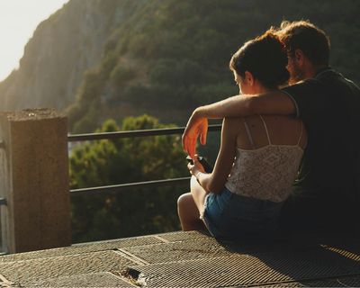 Couple enjoying a scenic mountain valley viewpoint at sunset in Patagonia.