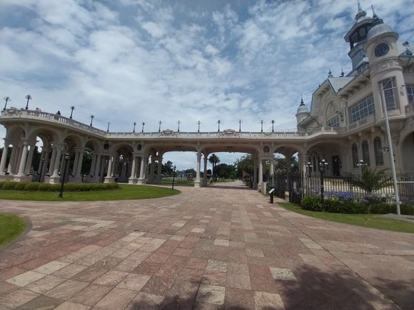 Grand neoclassical colonnade with ornate tower overlooking manicured grounds in Tigre, Buenos Aires.