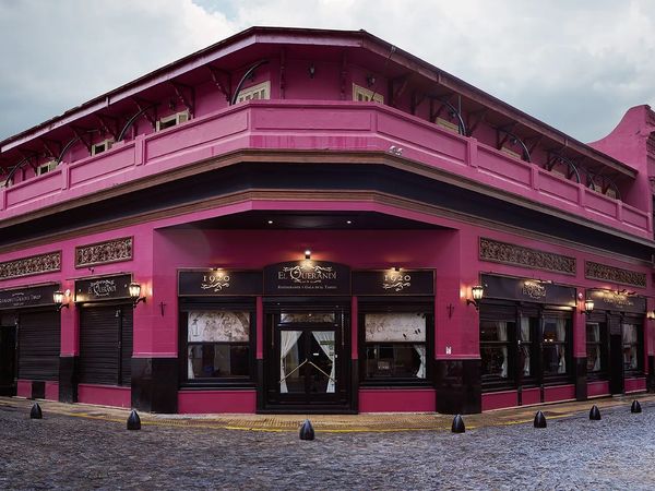 Vibrant pink colonial building El Querandi restaurant in historic La Boca neighborhood, Buenos Aires, Argentina.