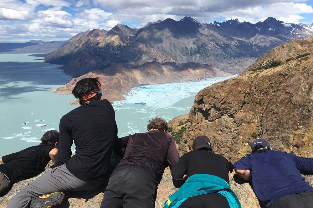 Hikers admire turquoise Glaciar Viedma and dramatic mountain peaks from Circuito Huemul viewpoint in El Chaltén, Patagonia.
