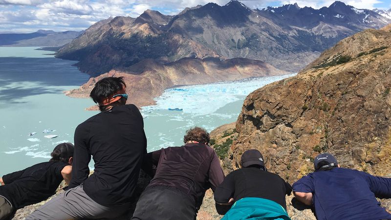 Hikers admire turquoise Glaciar Viedma and dramatic mountain peaks from Circuito Huemul viewpoint in El Chaltén, Patagonia.