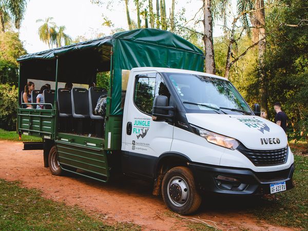 Jungle Fly safari truck with green canvas canopy parked in lush forest near Iguazú, offering adventurous wildlife tours.