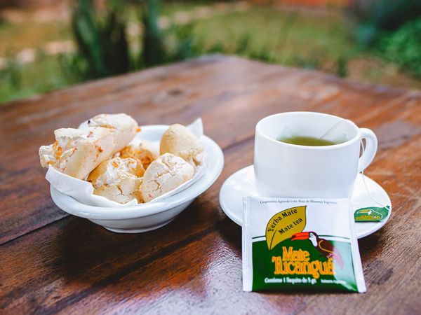 Yerba mate tea and regional pastries served outdoors in the Iguazú jungle landscape of Argentina.