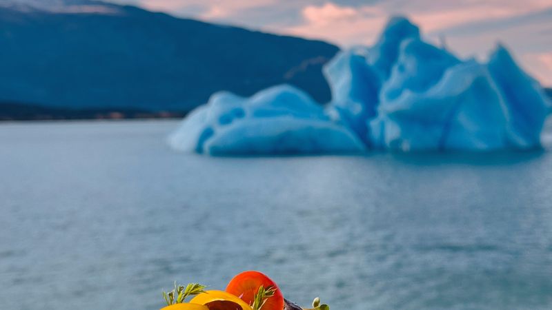 Gourmet soup with fresh vegetables overlooking a blue iceberg in Glaciar Perito Moreno, El Calafate.
