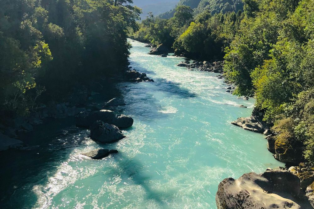 Turquoise river winds through lush forest canyon on Carretera Austral in Patagonia, Chile.