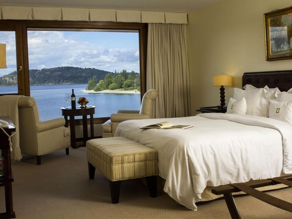 Luxury lakeside hotel room in Bariloche with panoramic views of Nahuel Huapi Lake and Patagonian forests.