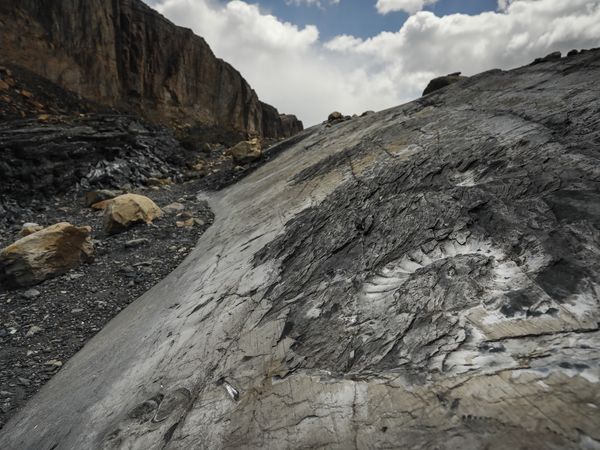 Dramatic mountainside scree slope and exposed rock formations along the Estancia Cristina trekking trail in Patagonia.
