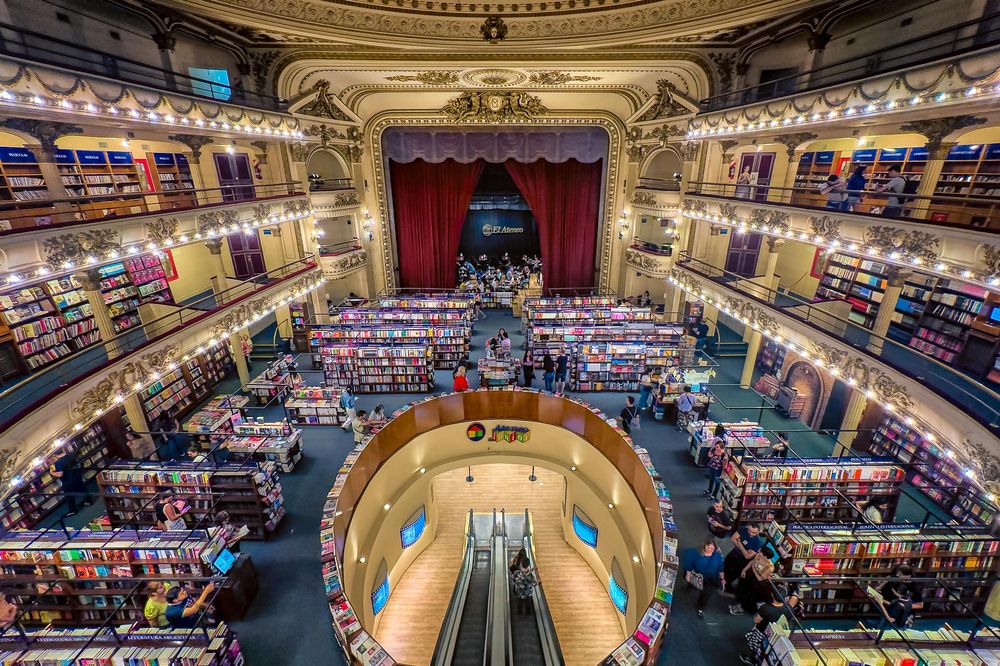 Ornate circular Buenos Aires bookstore with multiple levels of colorful books, grand architecture, and illuminated balconies.