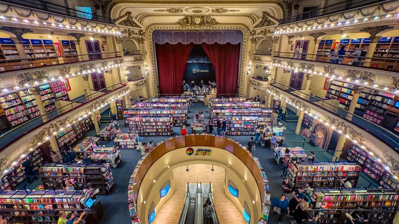 Ornate circular Buenos Aires bookstore with multiple levels of colorful books, grand architecture, and illuminated balconies.