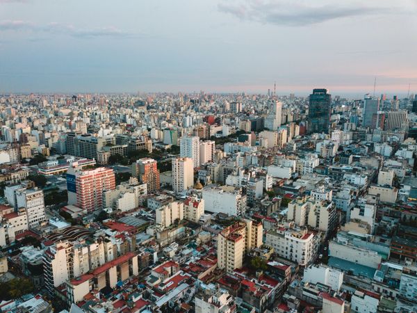 Aerial view of Buenos Aires cityscape at sunset with densely packed buildings and skyscrapers extending to the horizon.