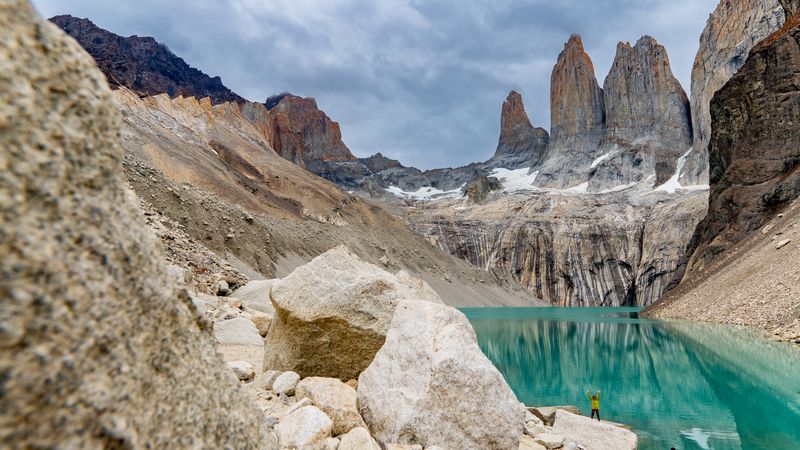 Turquoise glacial lake surrounded by granite peaks at Torres del Paine base trail in Patagonia, Chile.