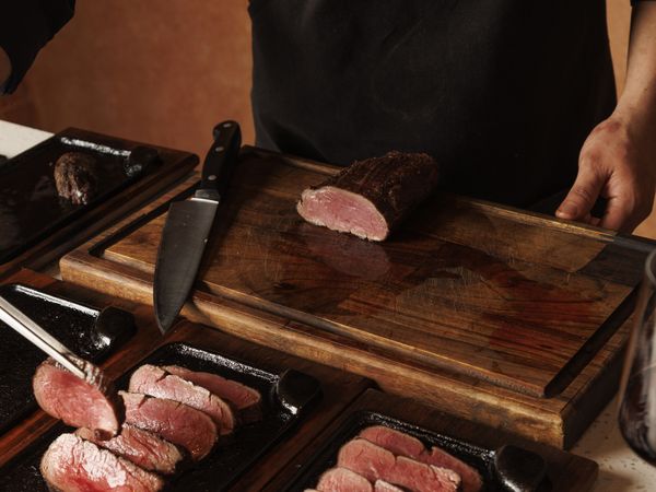 Argentine chef slicing grass-fed beef at a traditional Buenos Aires asado tasting experience.