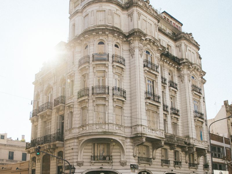 Historic Belle Époque building with ornate stone facade and corner tower in Buenos Aires historic district.
