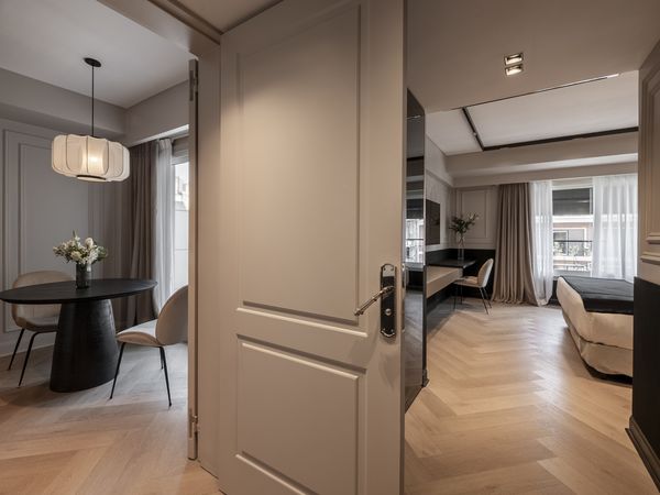 Luxurious modern apartment interior at CasaSur Recoleta featuring beige walls, herringbone flooring, and contemporary furnishings.