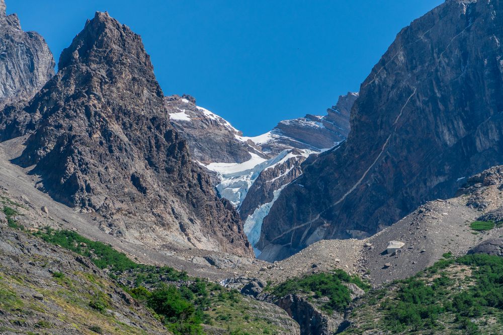 Glacial valley with turquoise ice between dramatic granite peaks in Torres del Paine National Park, Patagonia.