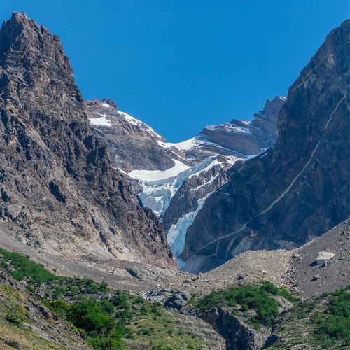 Glacial valley with turquoise ice between dramatic granite peaks in Torres del Paine National Park, Patagonia.
