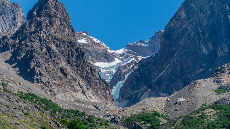 Glacial valley with turquoise ice between dramatic granite peaks in Torres del Paine National Park, Patagonia.
