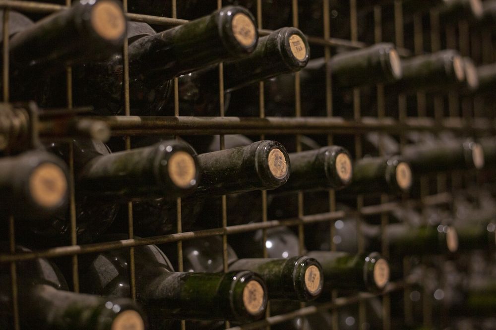 Aged wine bottles stacked horizontally in a Mendoza winery cellar, showcasing Argentina's renowned wine production heritage.