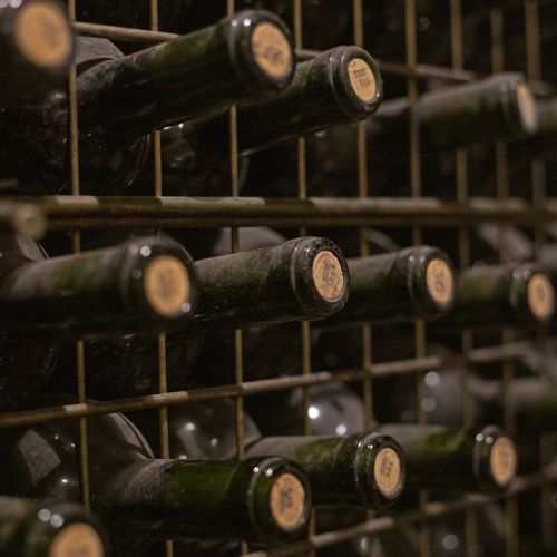Aged wine bottles stacked horizontally in a Mendoza winery cellar, showcasing Argentina's renowned wine production heritage.
