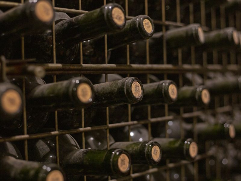 Aged wine bottles stacked horizontally in a Mendoza winery cellar, showcasing Argentina's renowned wine production heritage.