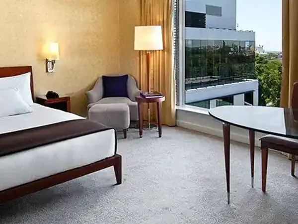 Luxury hotel room at Park Hyatt with modern furnishings, city views through floor-to-ceiling windows, and contemporary décor.