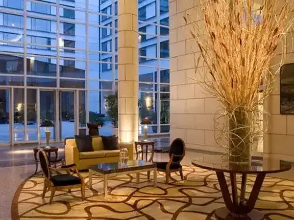 Modern luxury hotel lobby at Park Hyatt with elegant seating, floor-to-ceiling windows, and contemporary décor overlooking the city at dusk.