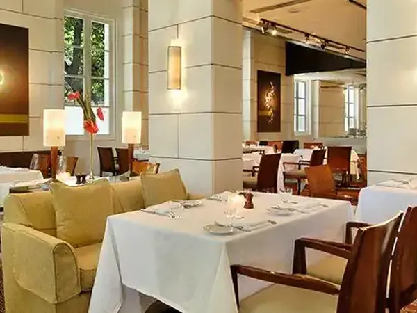 Elegant fine dining restaurant at Park Hyatt with white tablecloths, modern decor, and sophisticated ambiance.
