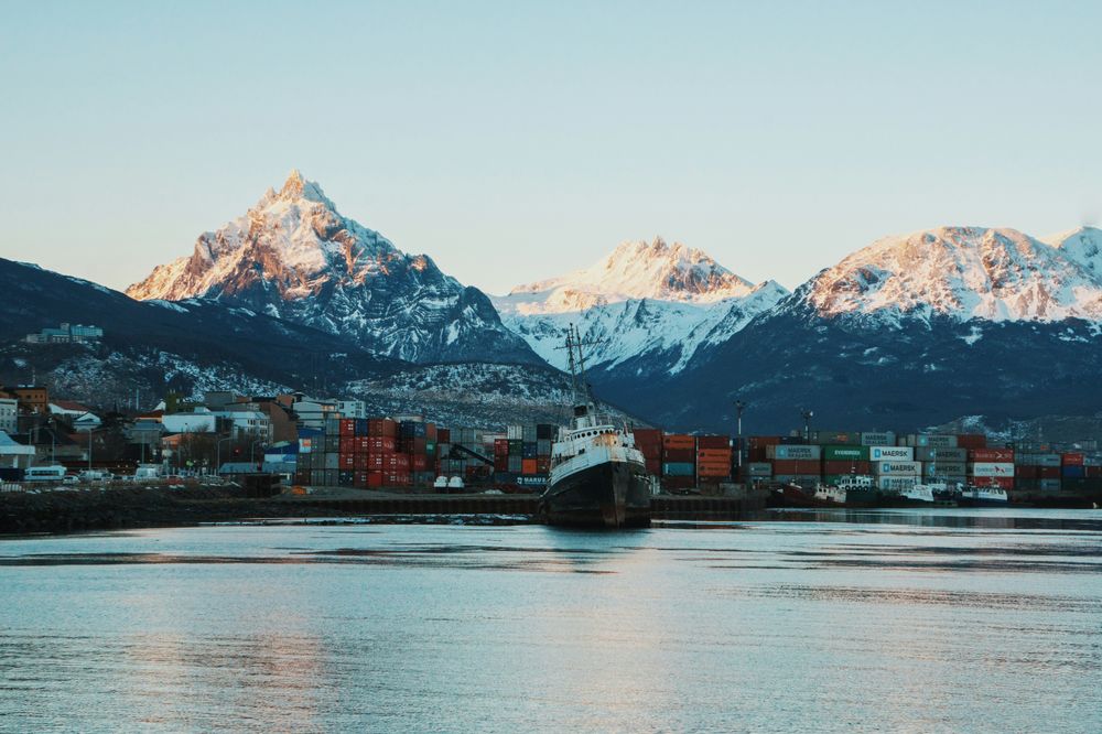 Snow-capped peaks rise behind a cargo ship docked at Ushuaia's port in Tierra del Fuego, Argentina.